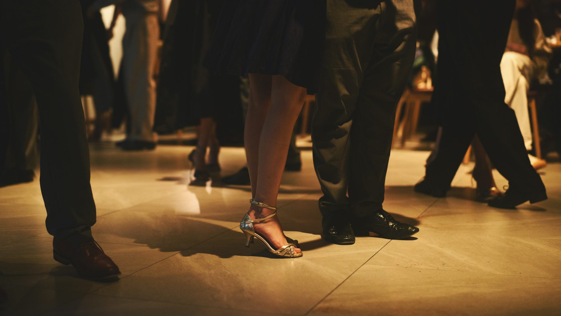 People dancing at a formal event with elegant shoes.